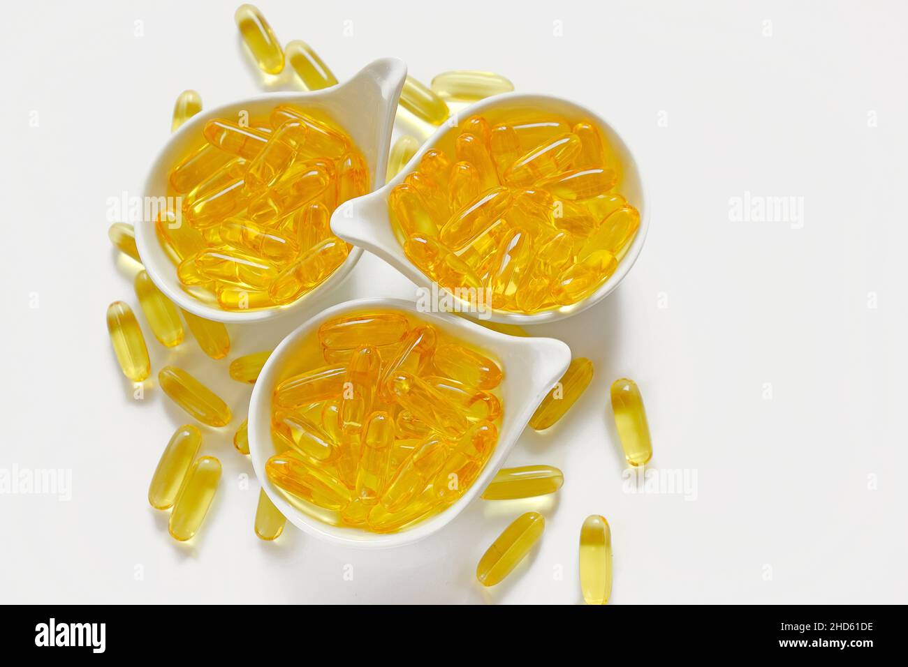 omega 3 gelatin capsules in white cups on a white background.omega