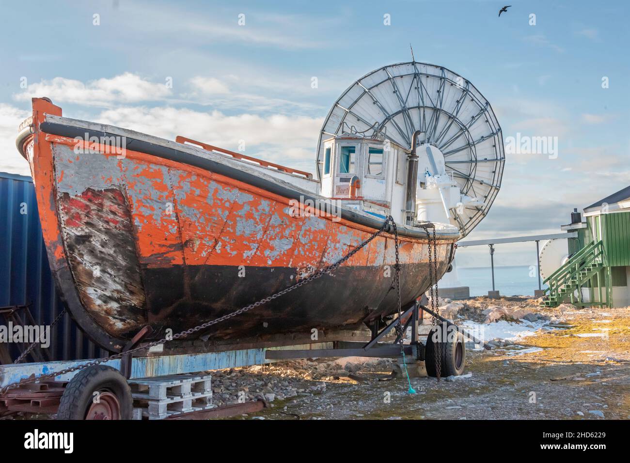 Old boat on trailer by modern satellite dishes, meteorological station, Ittoqqortoormiit, Scoresby Sund, Greenland Stock Photo