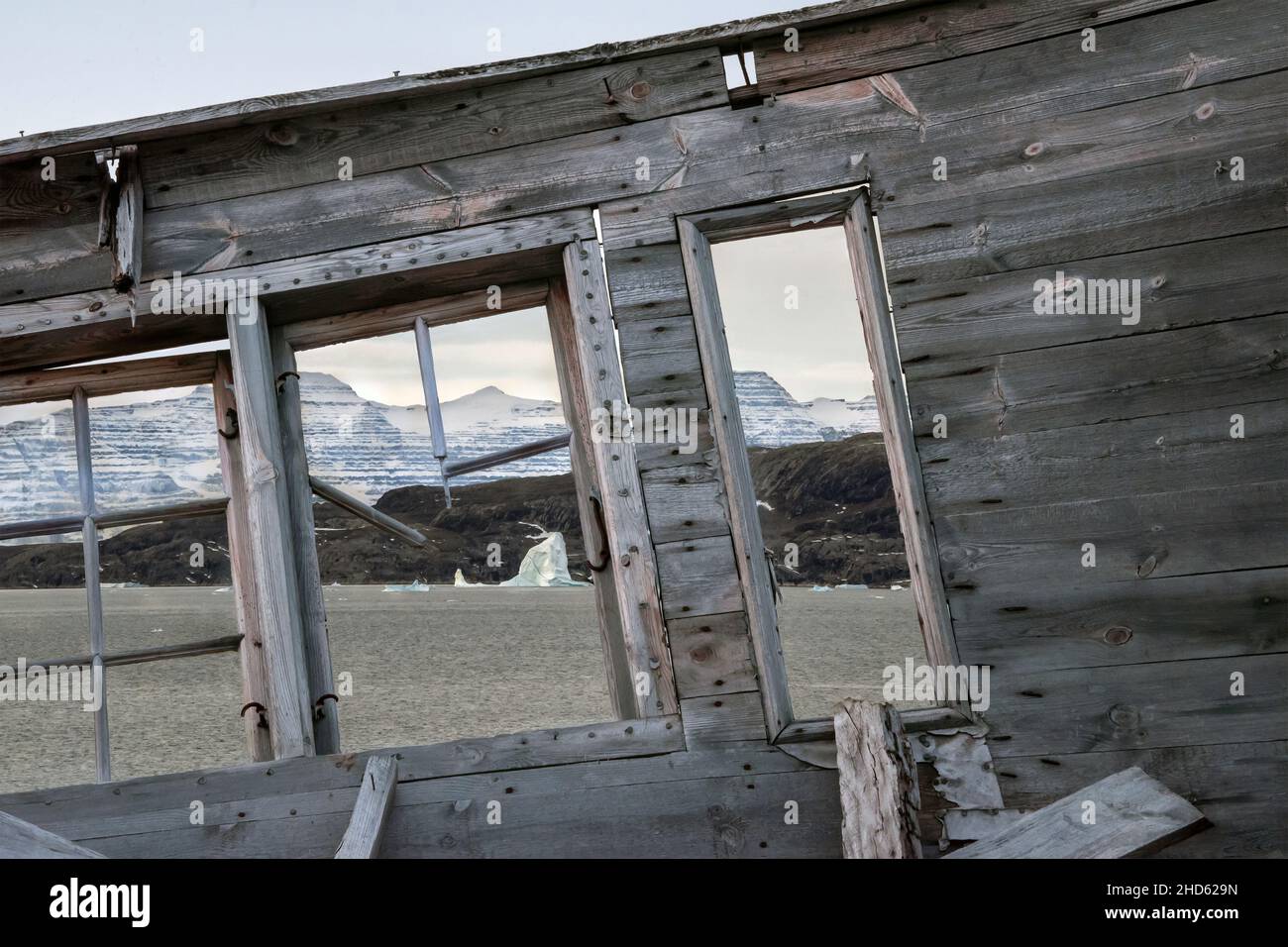 View of Fonfjord and Volquaart von Kyst mountains through the windows of abandoned cabin, Danmark O, Scoresby Sund, Greenland Stock Photo