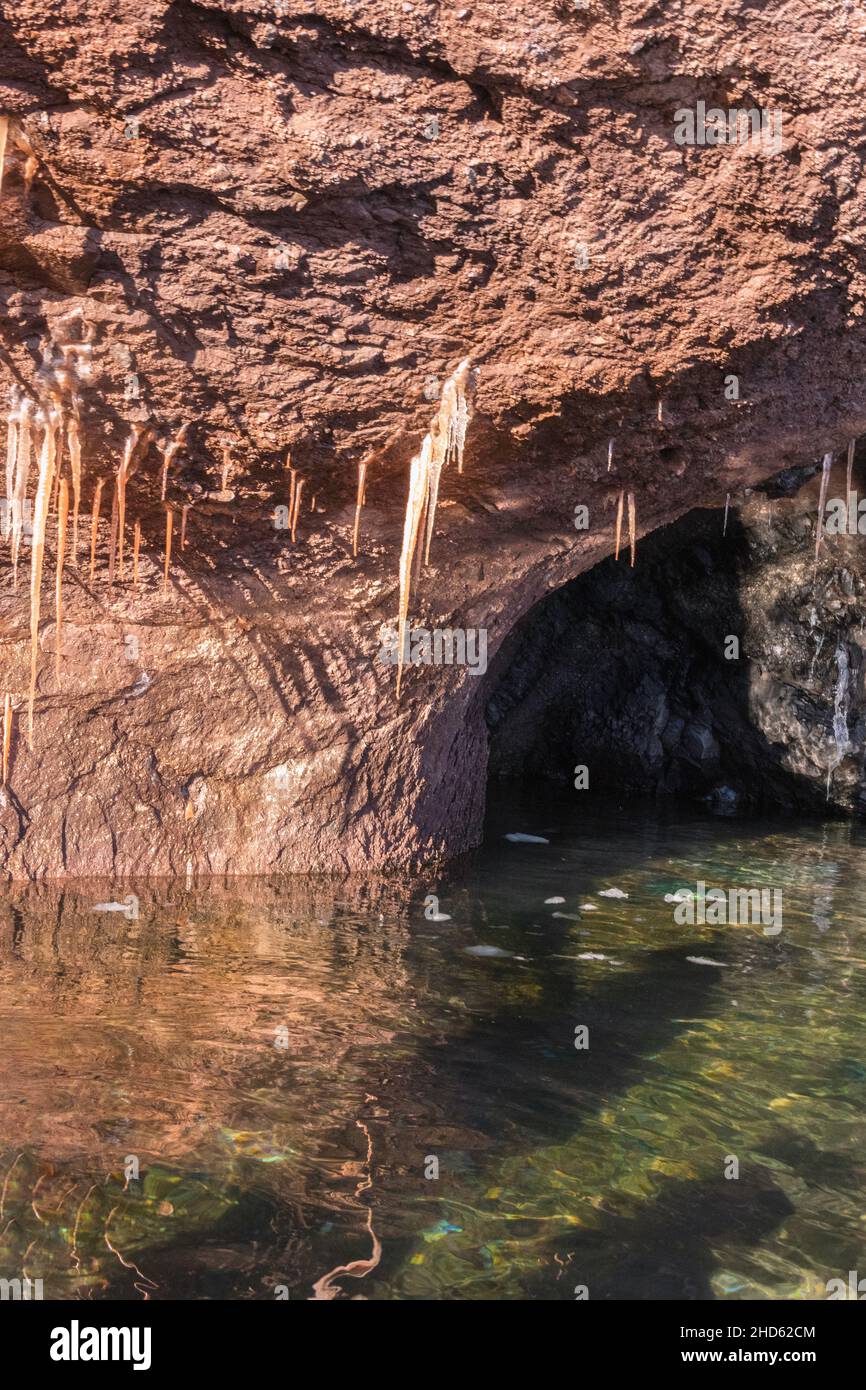 Icicles, reflections and cave, Rode O, Rodefjord, Scoresby Sund, Greenland Stock Photo