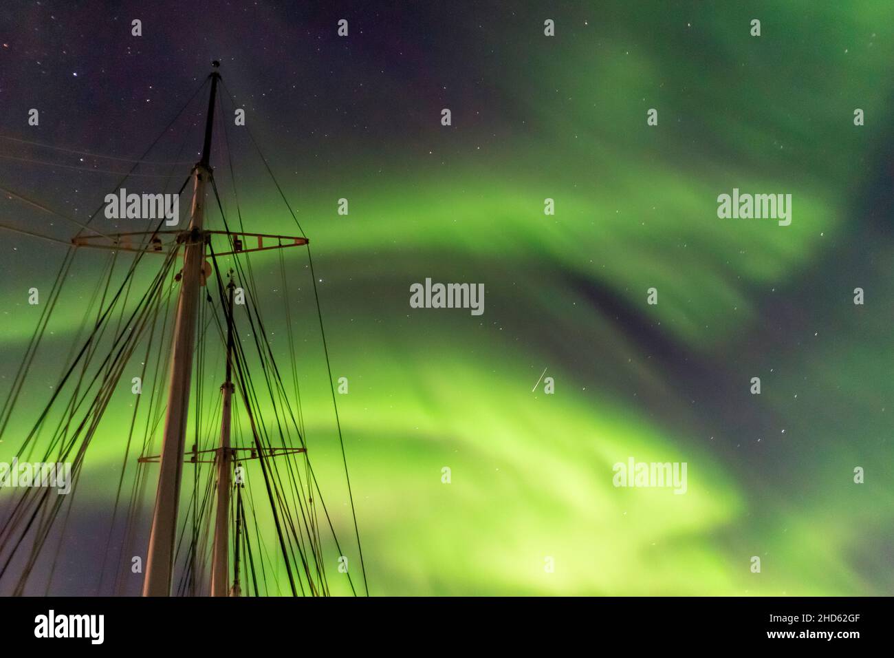 Ship's masts with northern lights, Rodefjord, Scoresby Sund, East Greenland Stock Photo