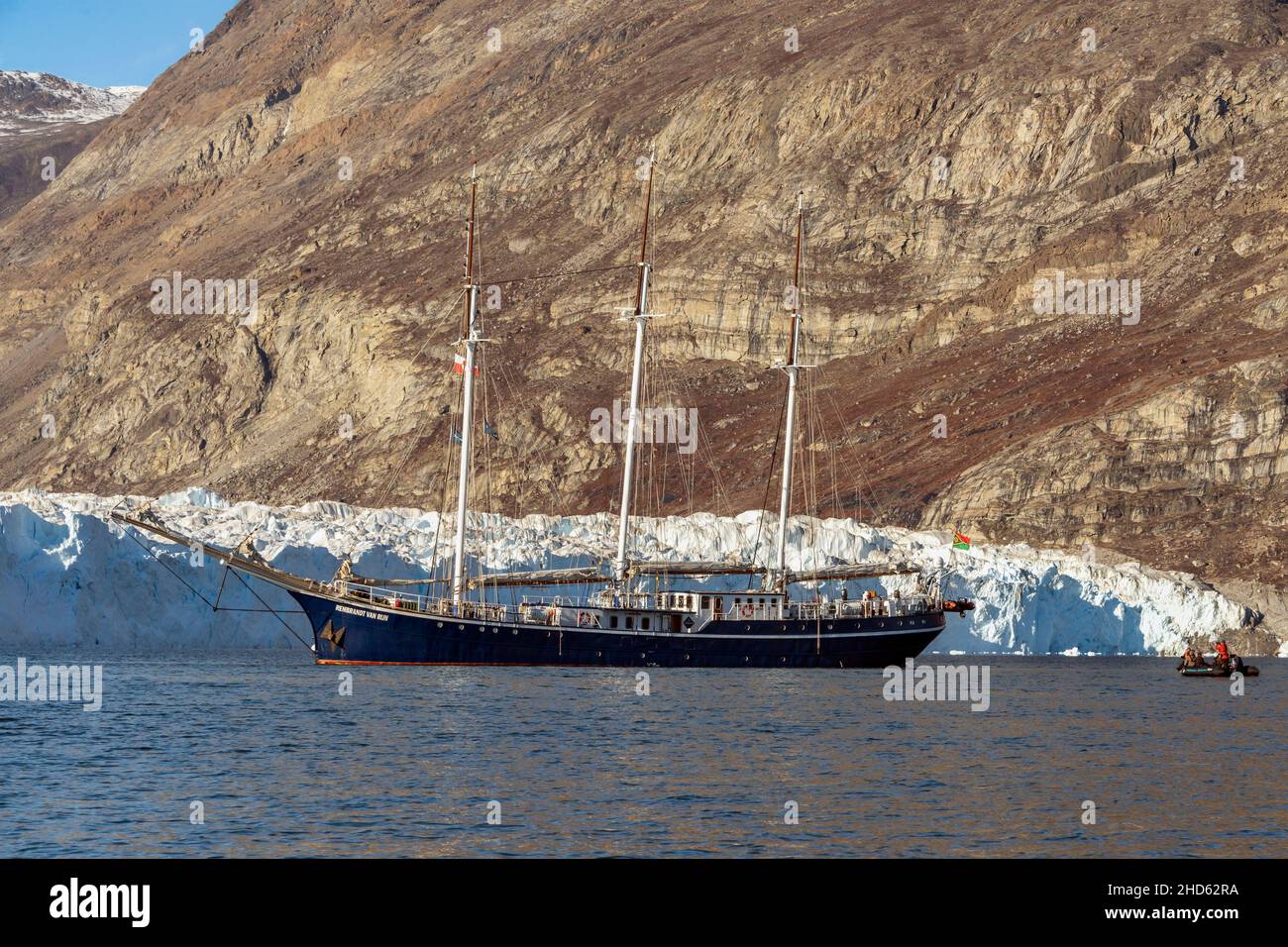 Rembrandt van Rijn anchored by the toe of the Rolige Brae Glacier with zodiac, Rodefjord, Scoresby Sund, Greenland Stock Photo