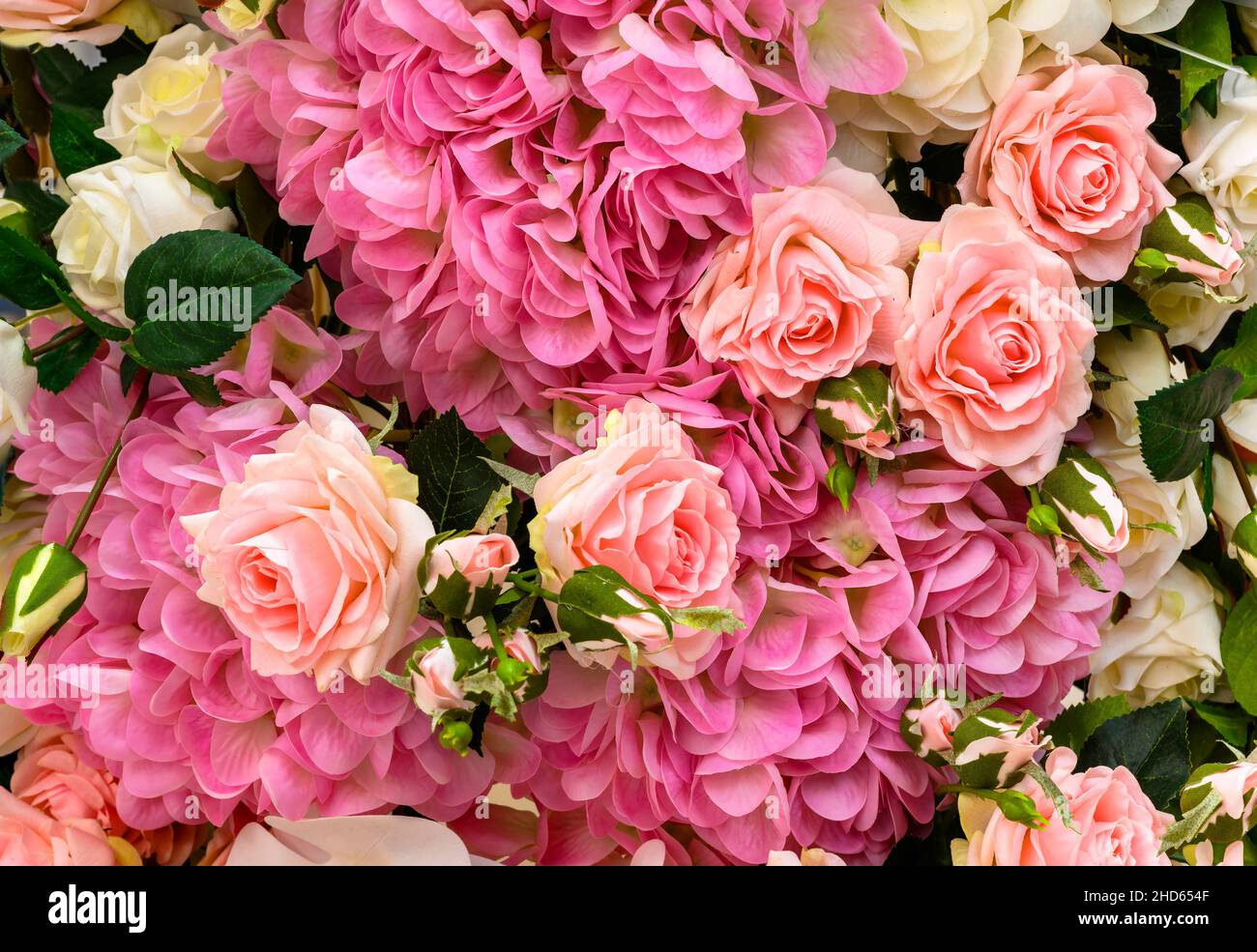 Rose and hydrangea flowers, top view of large bouquet of artificial flowers. Beautiful background of floral design with pink and white flowers. Nature Stock Photo