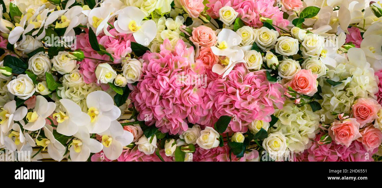 Various flowers background, panoramic top view of fresh orchids, roses and other flowers. Nice pastel pattern with beautiful flowers. Nature, wedding, Stock Photo
