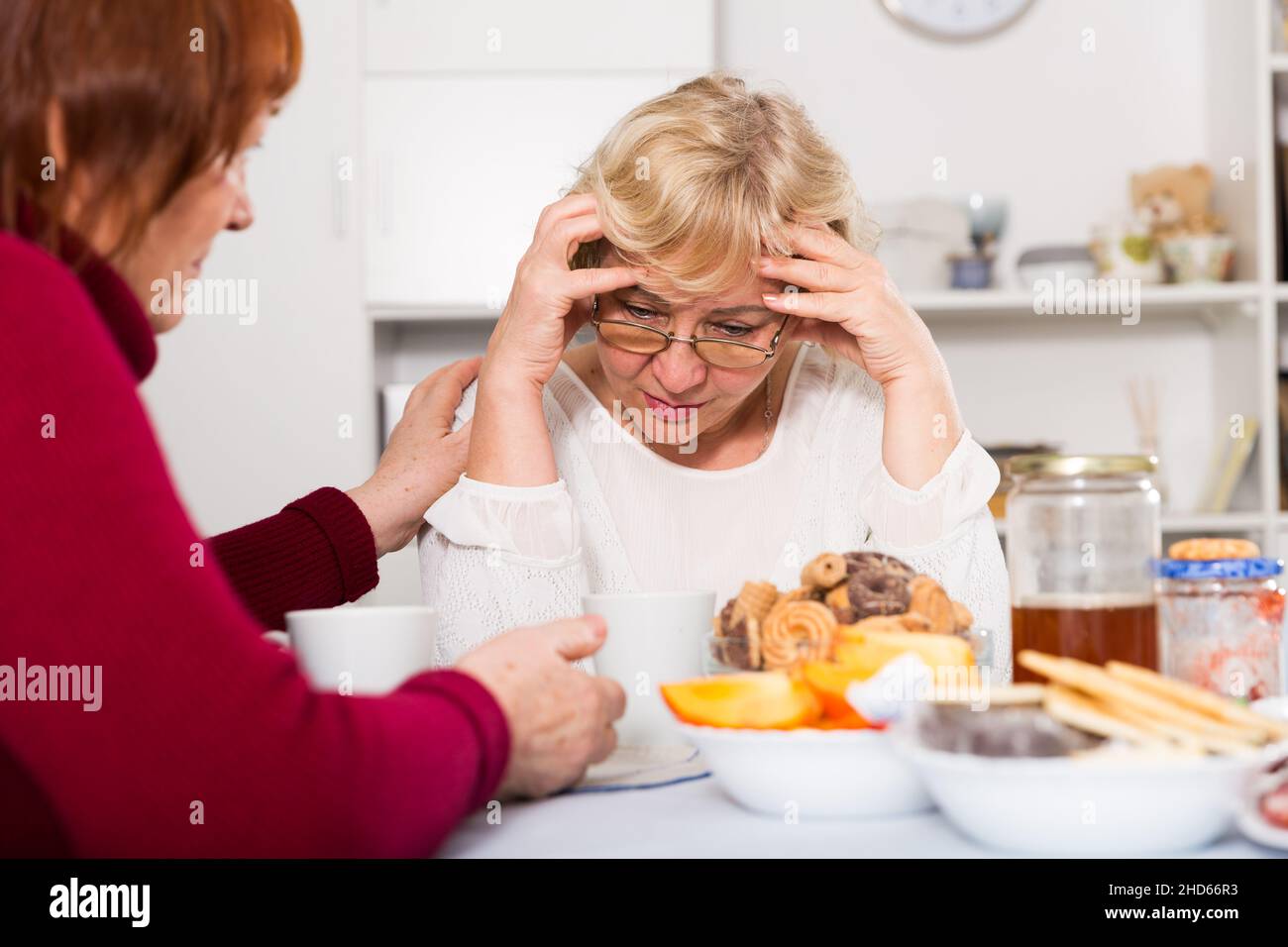Senior woman calming chagrined female friend Stock Photo - Alamy