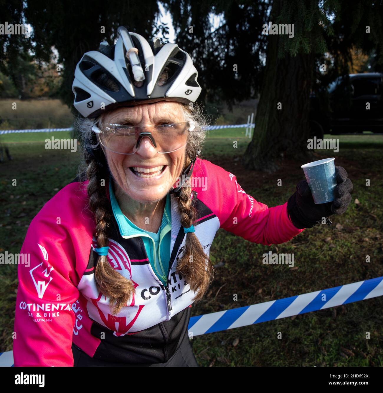 WA20624-00....WASHINGTON - Vicky Spring a 68 year old woman cyclocross racer celebrates the end of the race with a cup of champagne. .  MR# S1 Stock Photo