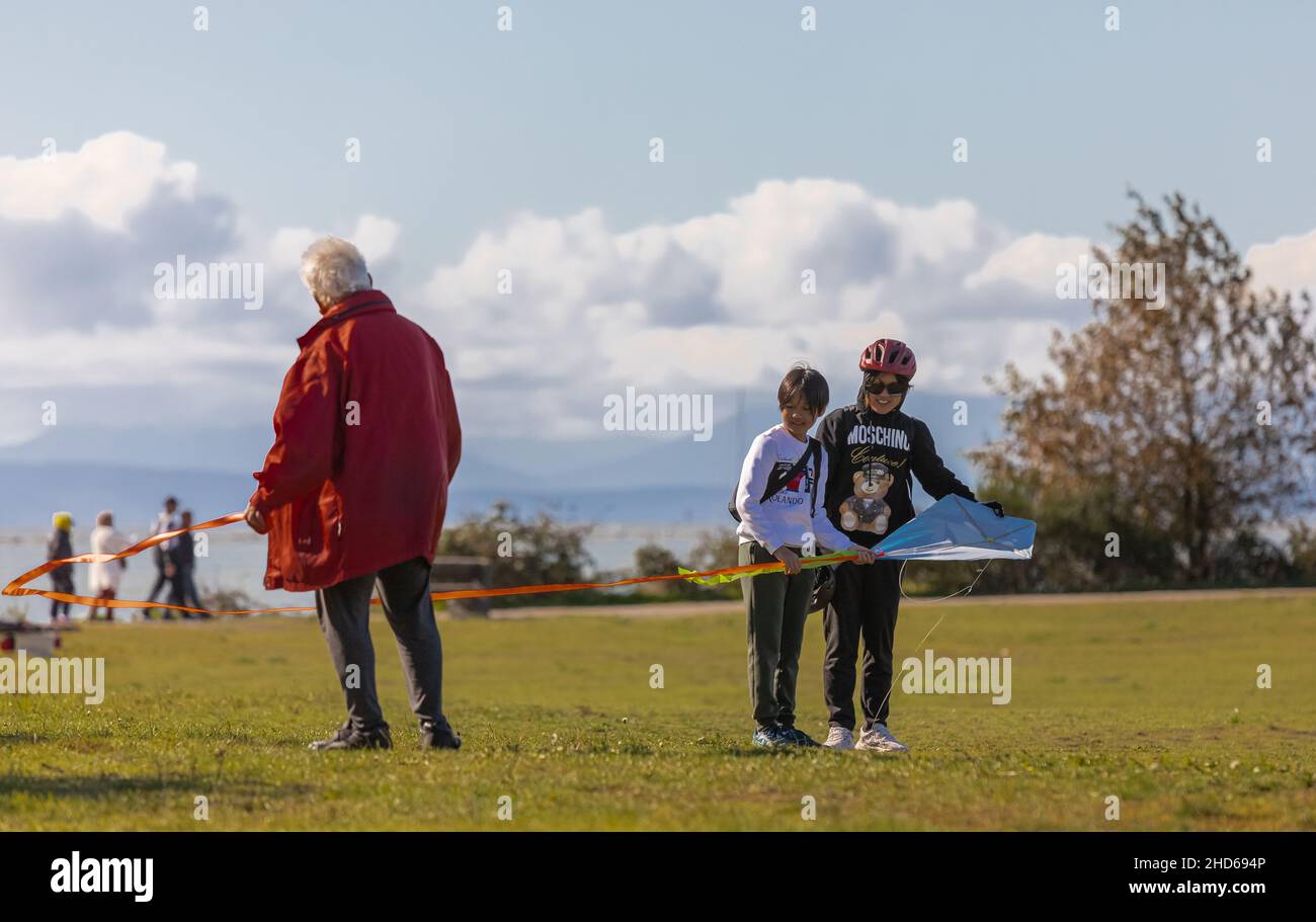 Happy family of three playing in the park Richmond BC, Canada-October 11,2021. Asian family grandfather and grandchildren spending time together. Stock Photo