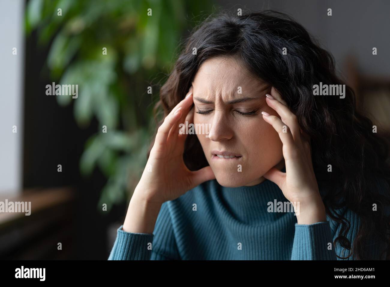 Unhappy stressed woman suffering from headache at workplace, anxious female having pain in head Stock Photo