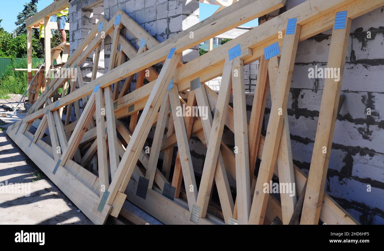 A closeup of a wooden roof truss components, webs, rafters, braces