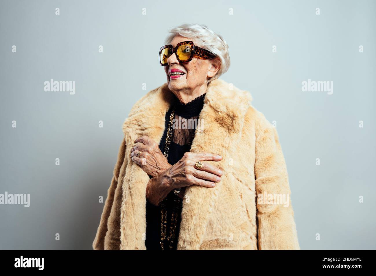 image of a beautiful and elegant old influencer woman. Cool grandmother posing in studio wearing fashionable clothes. Stock Photo