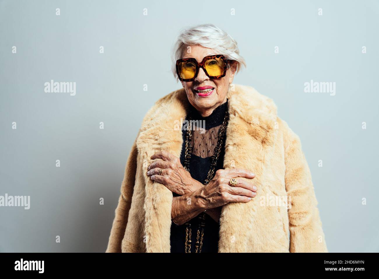 image of a beautiful and elegant old influencer woman. Cool grandmother posing in studio wearing fashionable clothes. Stock Photo