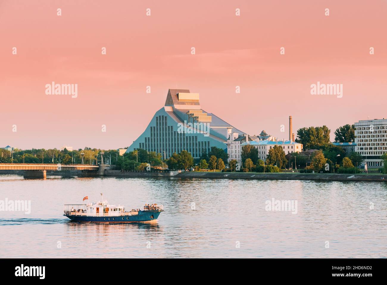 Riga, Latvia. Pleasure Boat Floating On Daugava River With View Of National Library On Background. Stock Photo
