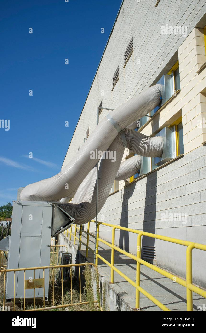 Temporary air conditioning machinery outdoors. Huge tubes are inserted from outside. Stock Photo