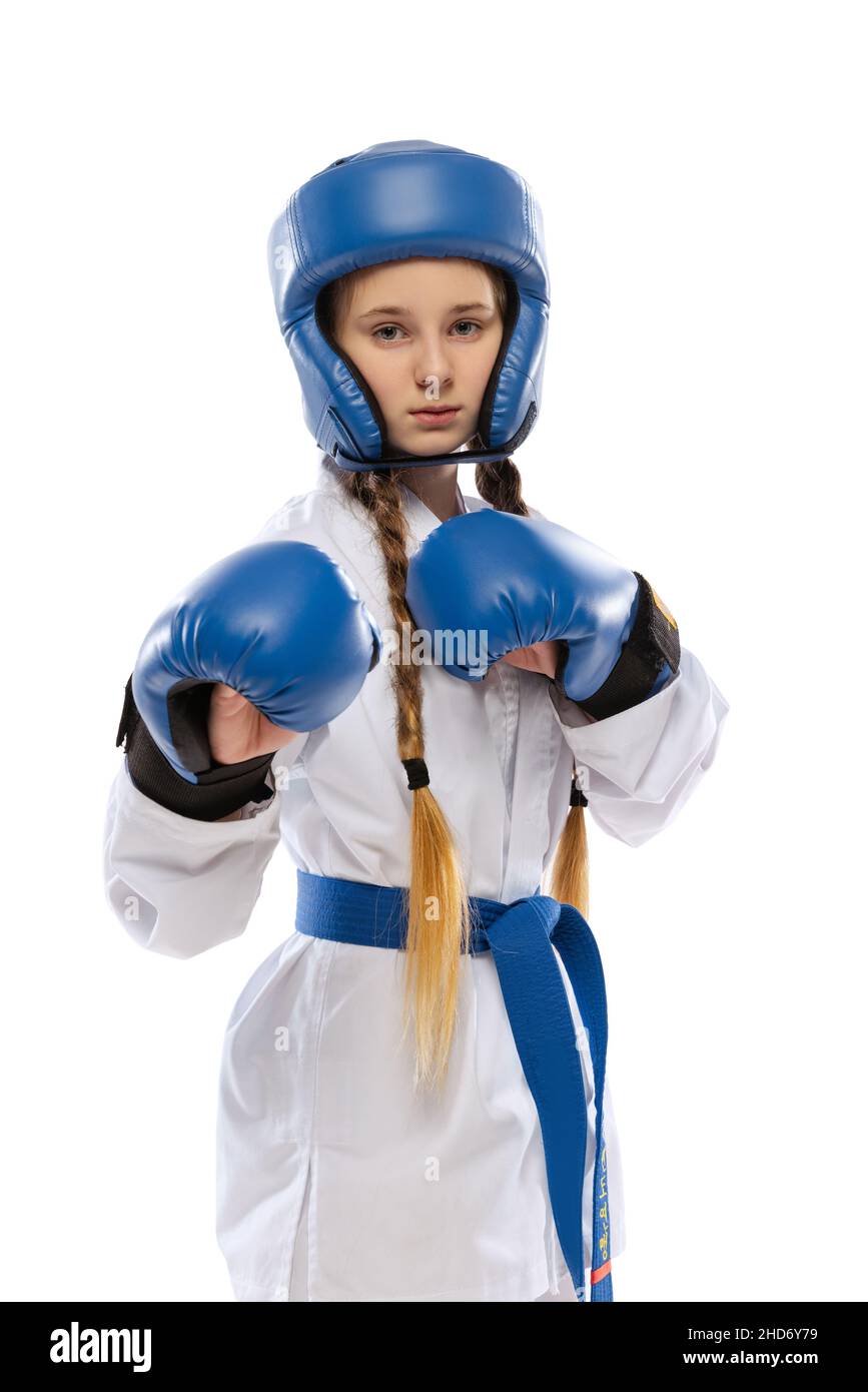 Half-length portrait of young girl, taekwondo athlete wearing dobok and sports defense uniform posing isolated on white background. Stock Photo