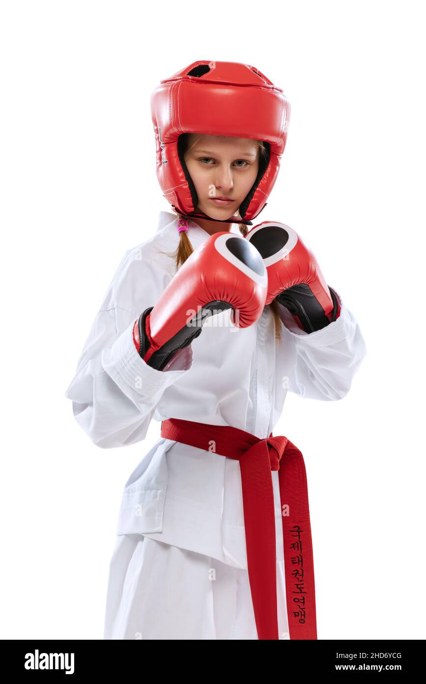 Half-length portrait of young girl, taekwondo athlete wearing dobok and sports defense uniform posing isolated on white background. Stock Photo