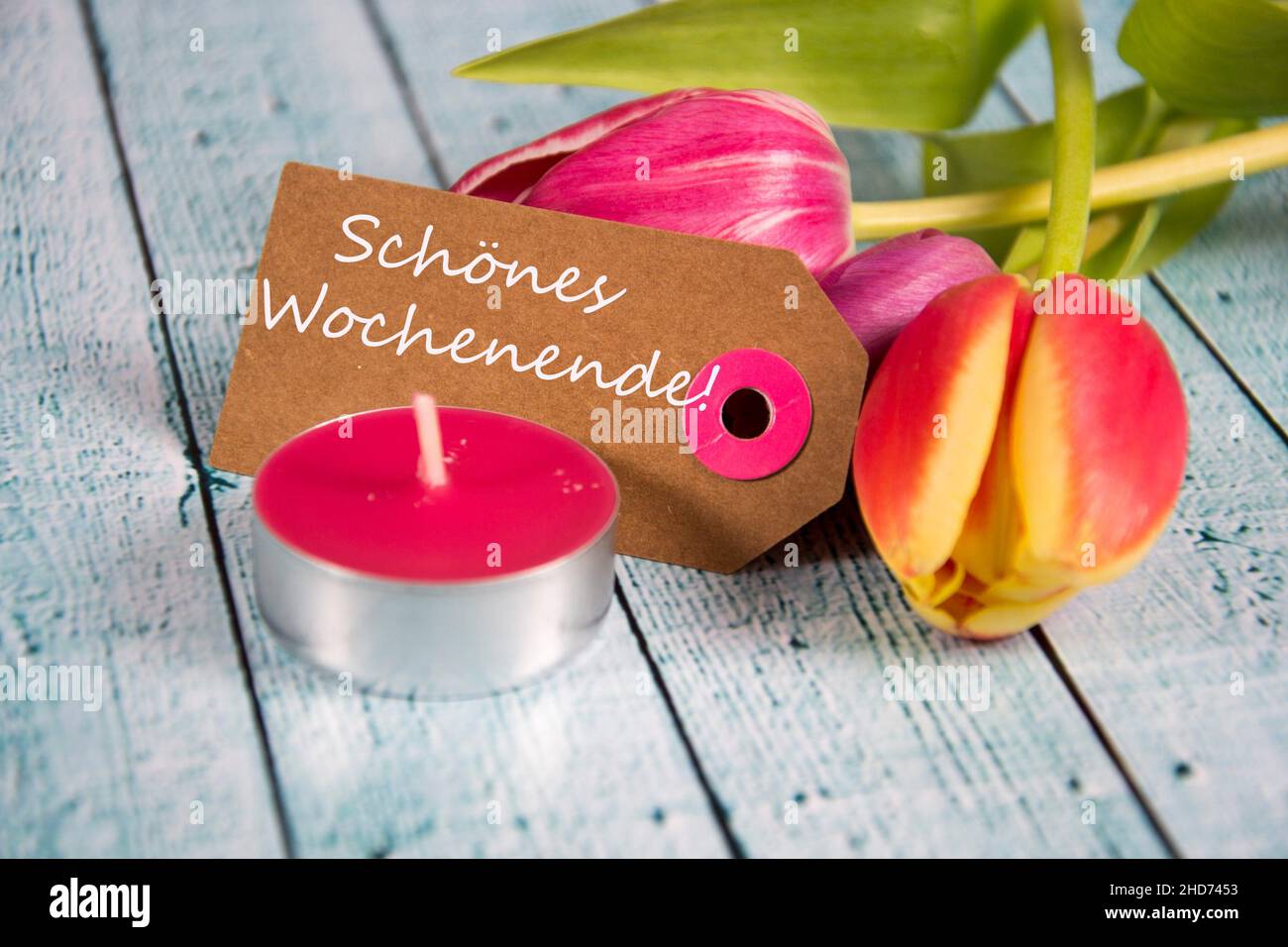 Schönes Wochenende! inscription written on paper tag. Stock Photo
