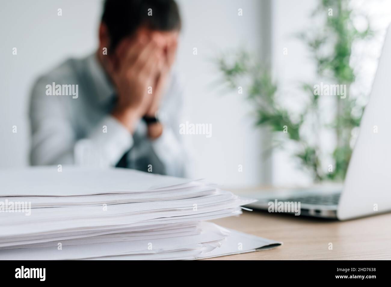 Businessman crying in the office, man covering face with hands and bursting in tears, selective focus Stock Photo