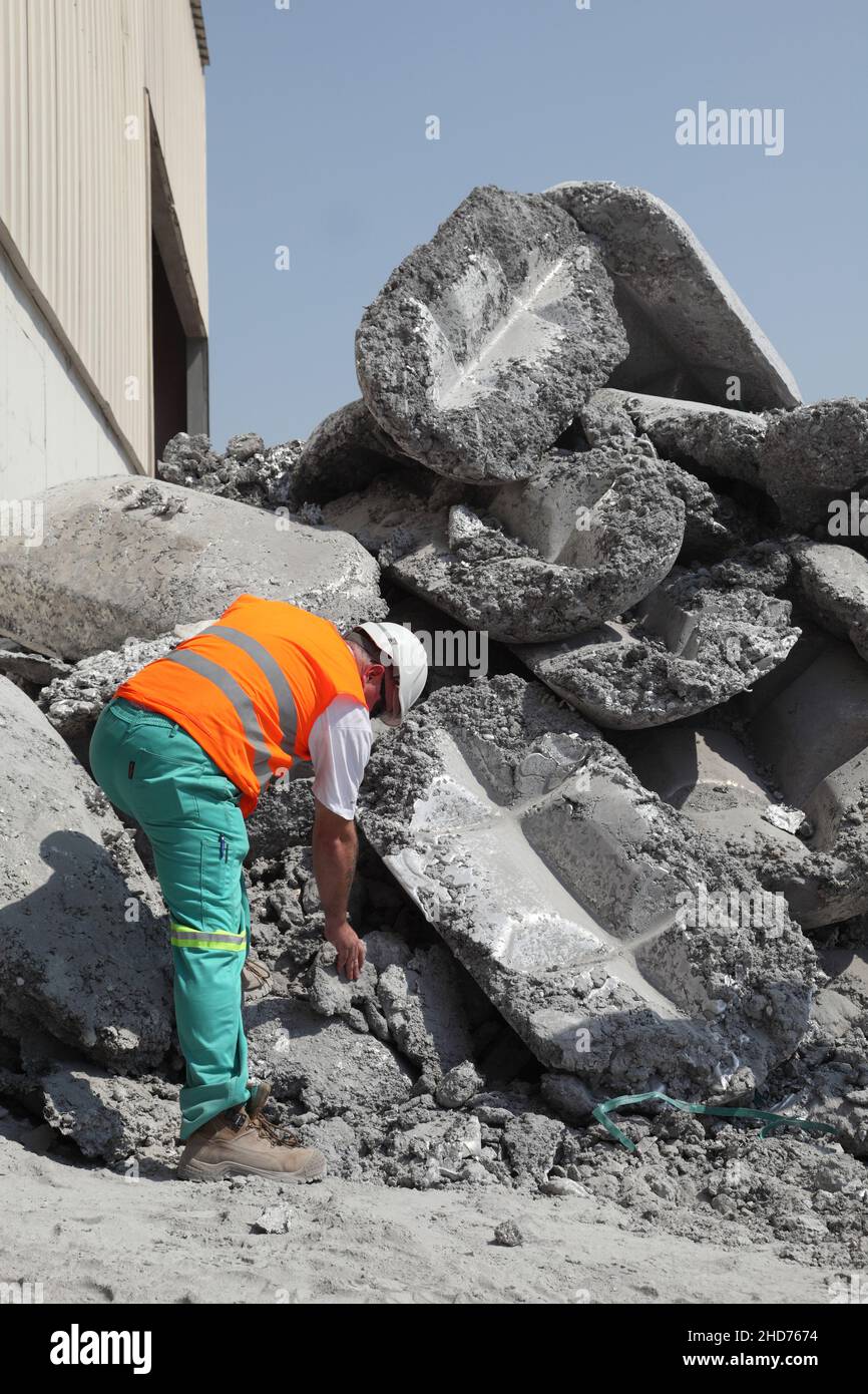 Bahrain. A manager examines aluminium salt cake prior to processing to recover the residual aluminim. Stock Photo