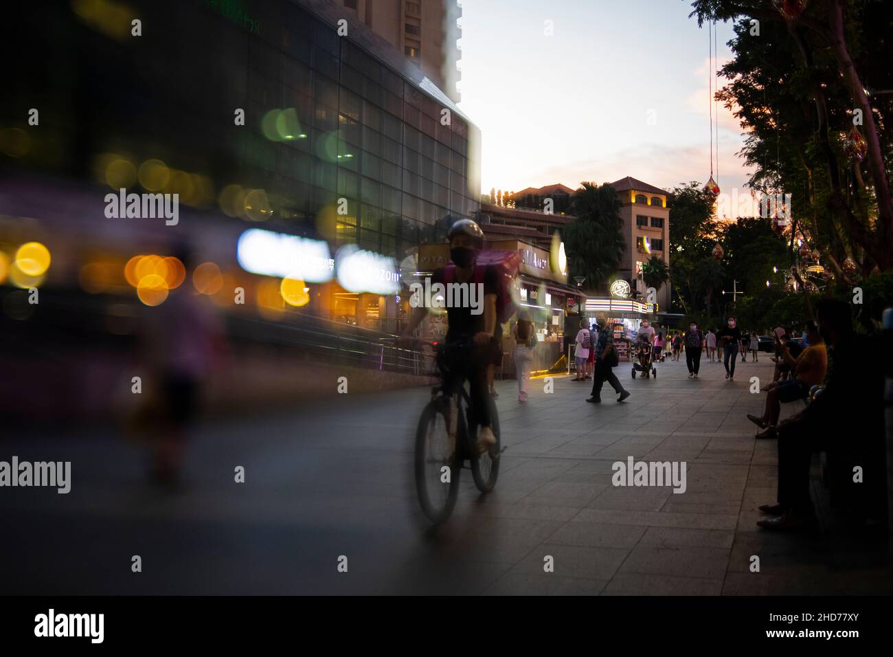 Food delivery man cycling on Orchard Road in Singapore Stock Photo