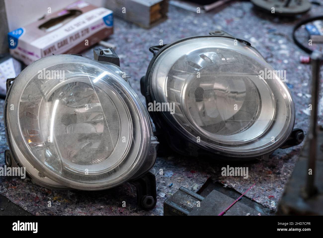 Detail of Car lights used spare parts in a workshop desk Stock Photo