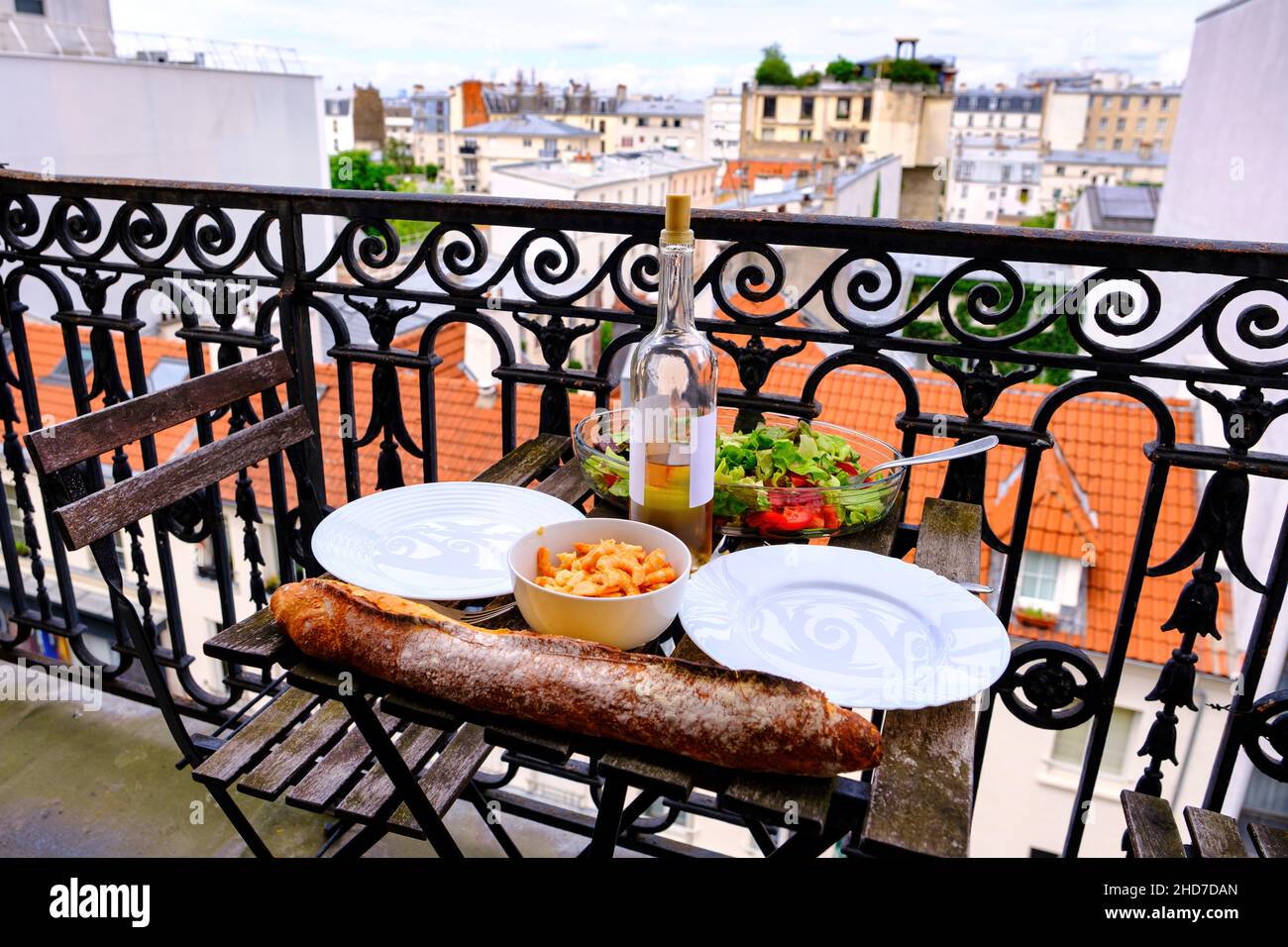french breakfast on a balcony -table, baguette, wine and view of Paris, France Stock Photo