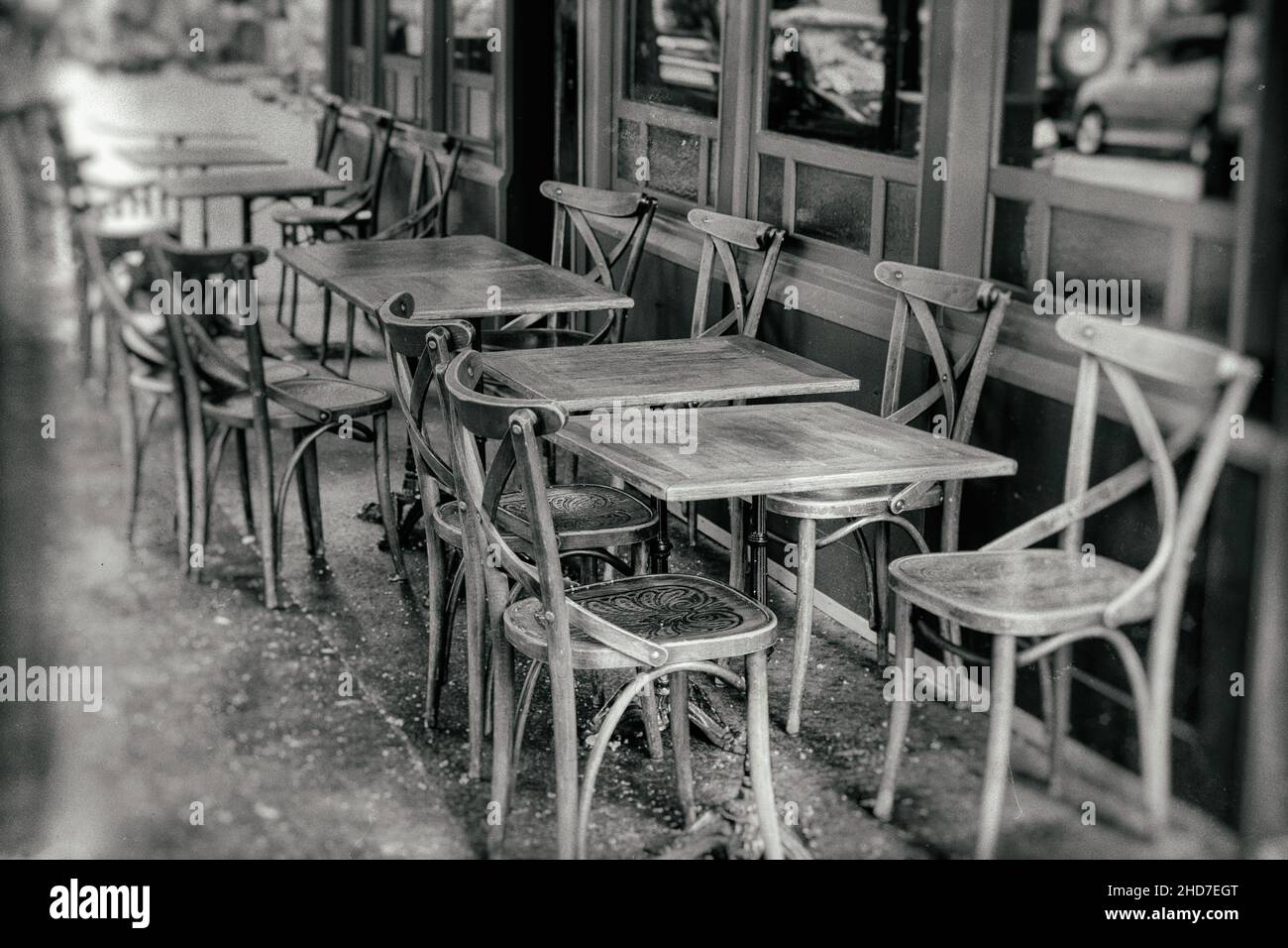 french restaurant - tables and chairs in the row on the street - Paris, France - vintage stylized black and white with dust and scratches Stock Photo