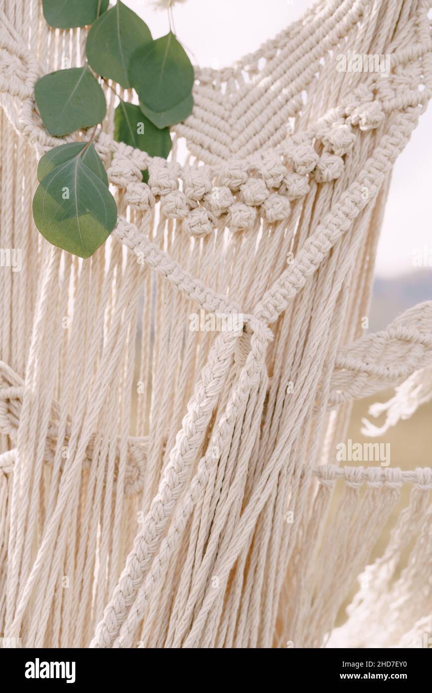 Knitted lace white macrame decorated with green leaves Stock Photo