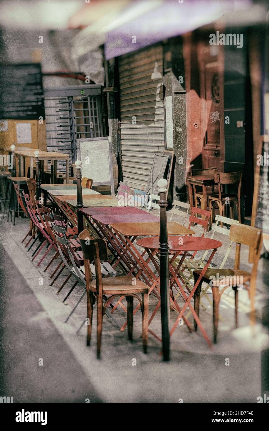french restaurant - tables and chairs in the row on the street - Paris, France - vintage stylized analog look with dust and scratches Stock Photo