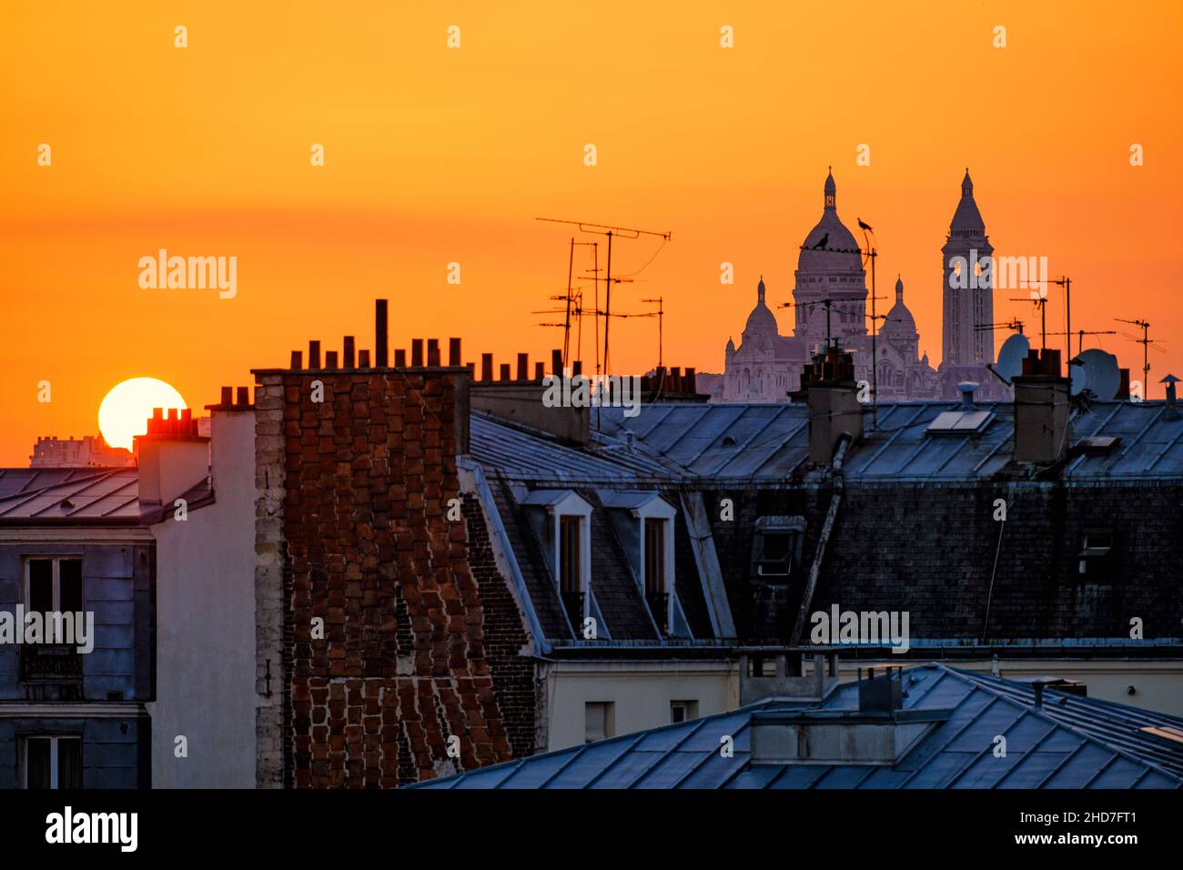 Basilica Sacre Coeur in Paris at sunset with orange sky Stock Photo