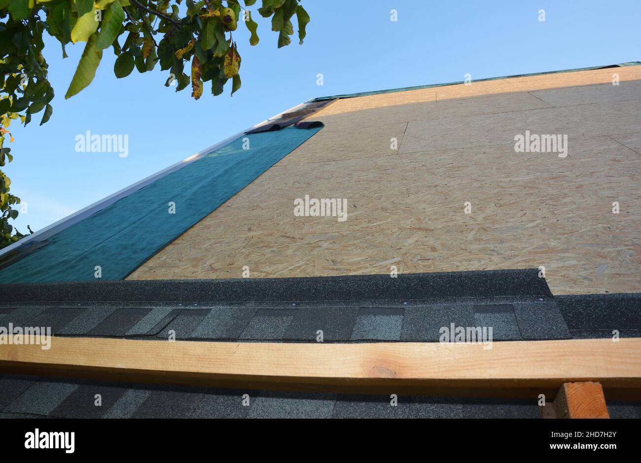 New roofing construction and asphalt shingles installation. A closeup