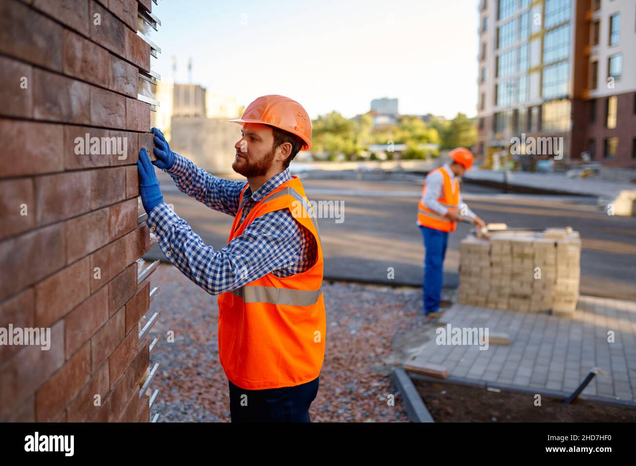 Worker cladding stone for external wall warming Stock Photo