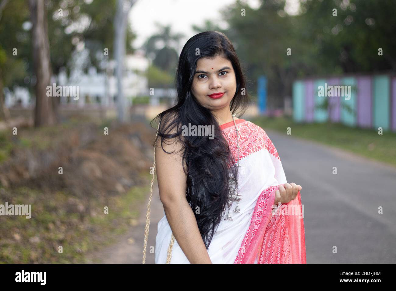 A pretty Indian woman in red saree and long hair posing for camera on road Stock Photo - Alamy A pretty Indian woman in red saree and long hair posing for camera on road Stock Photo - Alamy