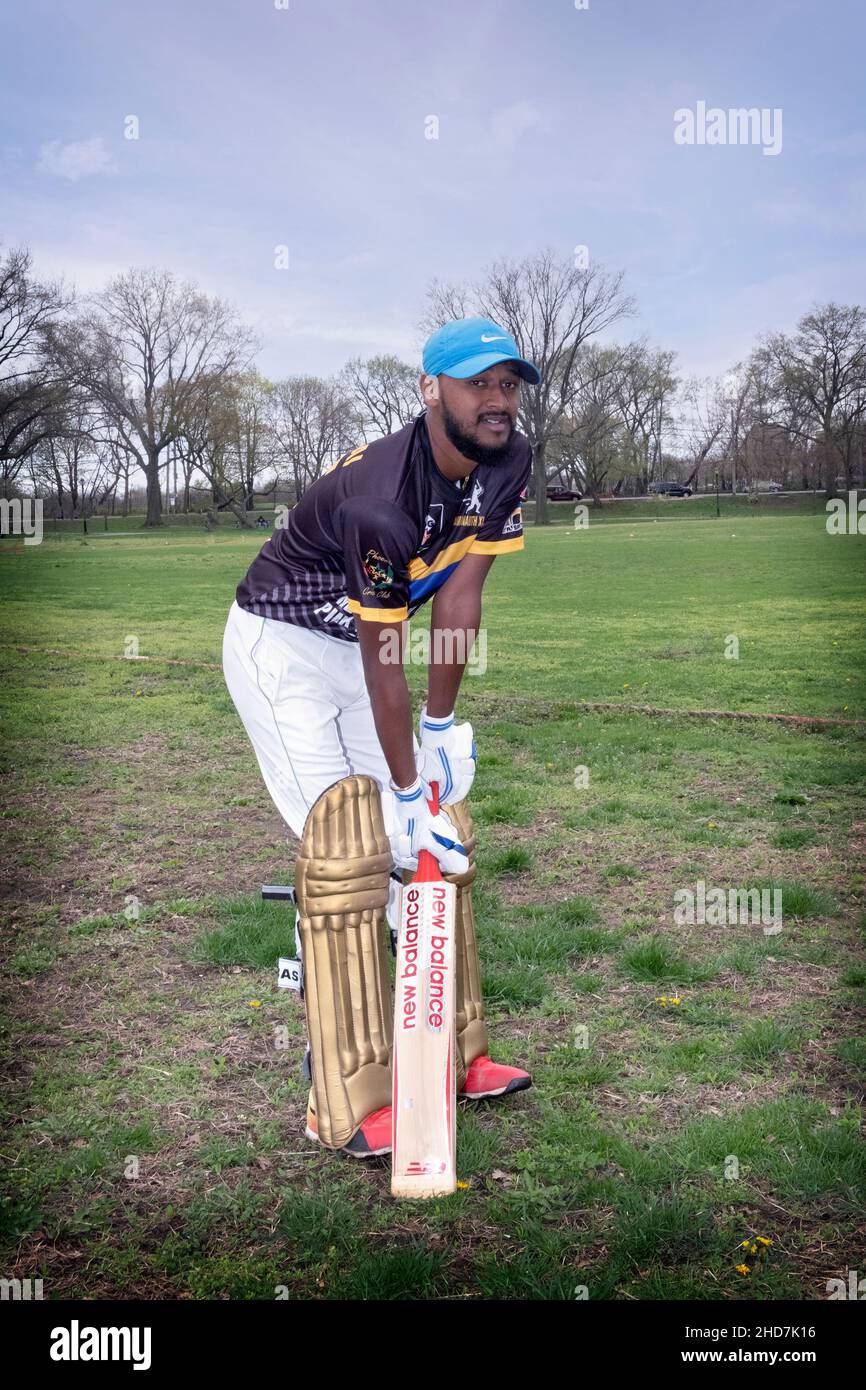 A Guyanese American cricket batsman in his 20's posing for a photo at a tournament in Baisley Pond Park in Jamaica, Queens, New York City. Stock Photo