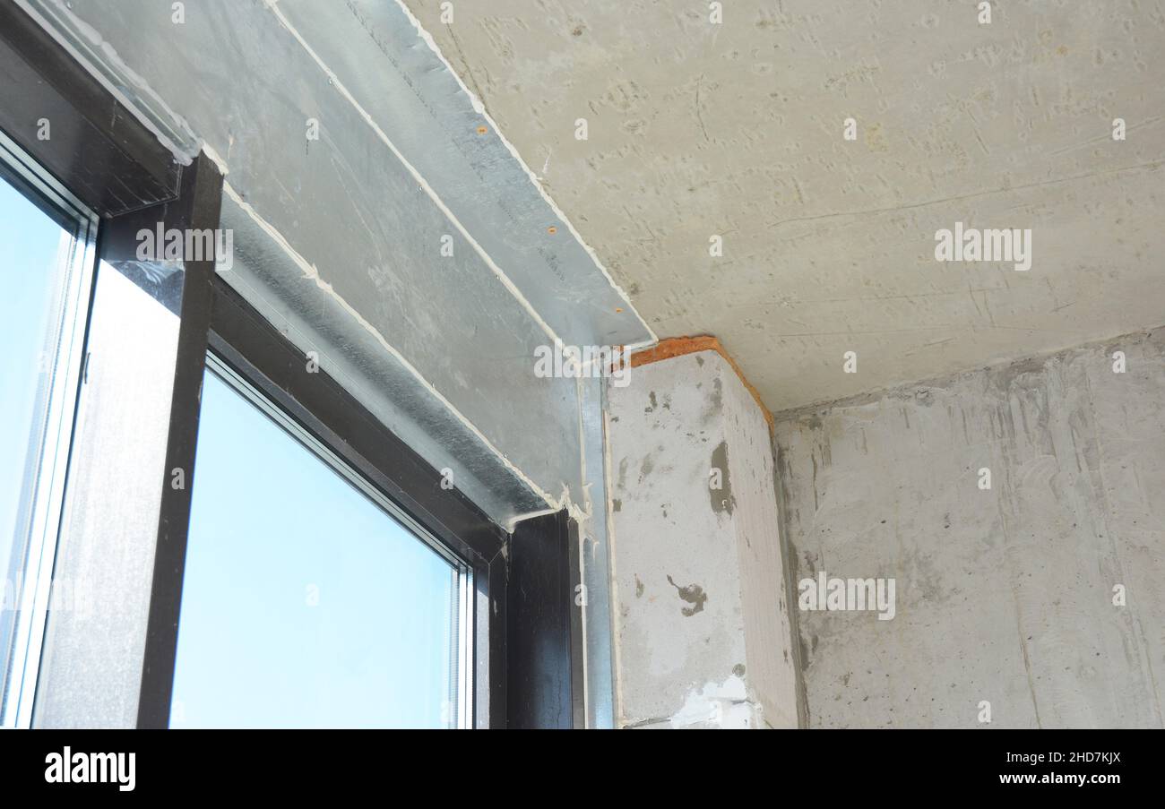 A balcony glass door, window is installed with a metal steel lintel, metal construction, panel above, connecting the ceiling and the balcony door. Stock Photo
