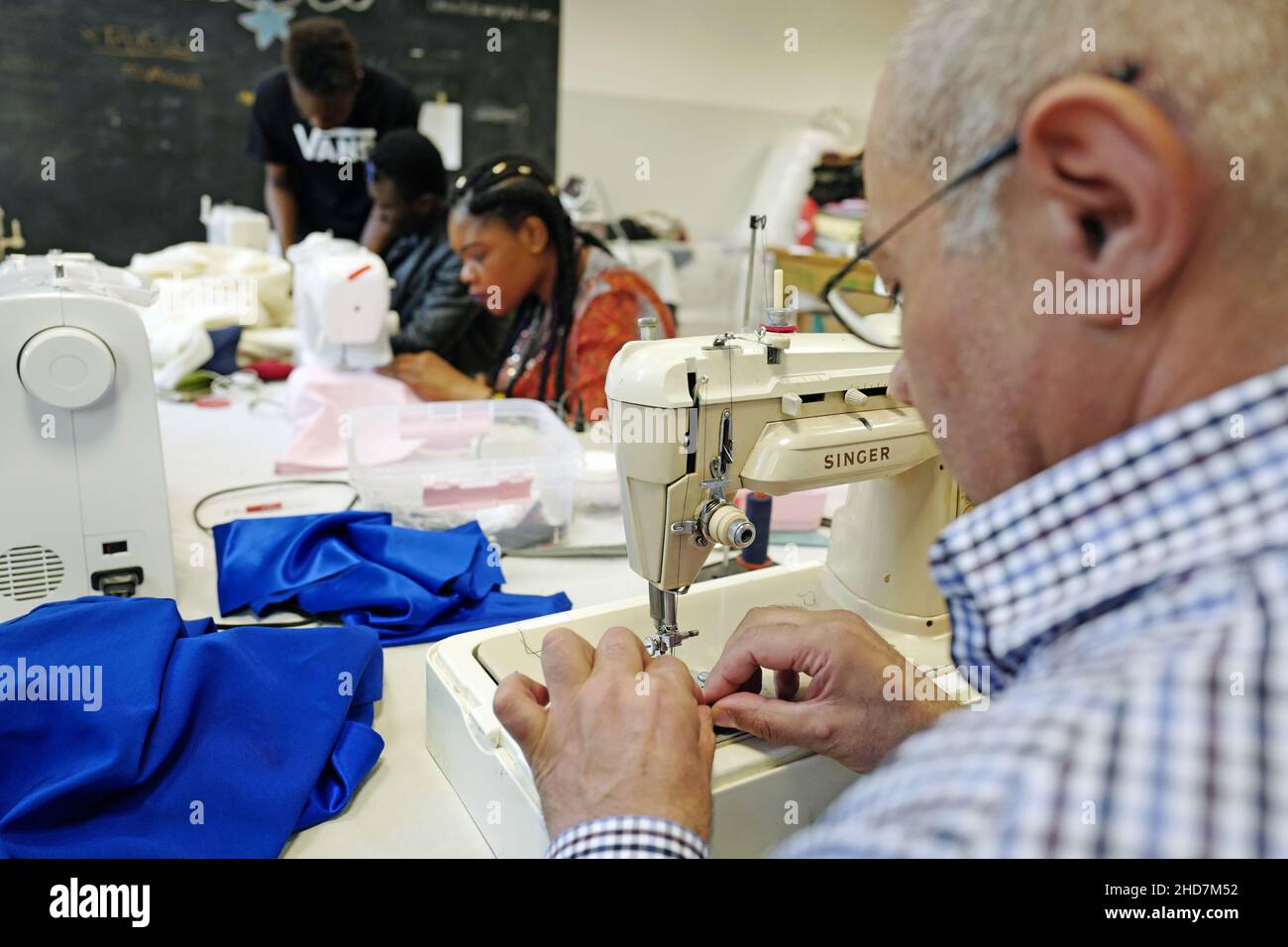 Political refugees working on a tailoring of the no-profit association Linea Adele, in Milan. Stock Photo