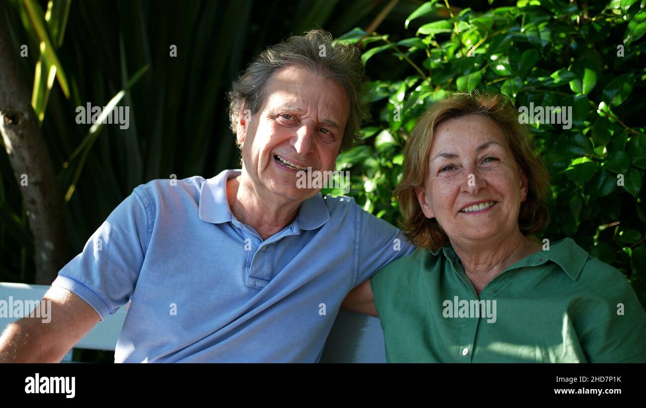Happy senior couple sitting outside at park bench Stock Photo - Alamy