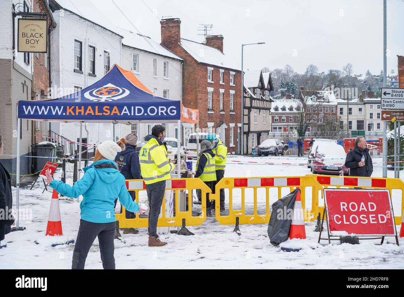 Bewdley, UK. 24th January, 2021. All hands are on deck today helping in the cleanup in Bewdley from flood damage. Free hot food is being served to those in need and helping out. Cooked and served by Khalsa Aid (Khalsa Aid International is a UK-based humanitarian relief charity, who provide support to victims of natural and man made disasters) who are set up outside the Black Boy public house. Credit: Lee Hudson Stock Photo