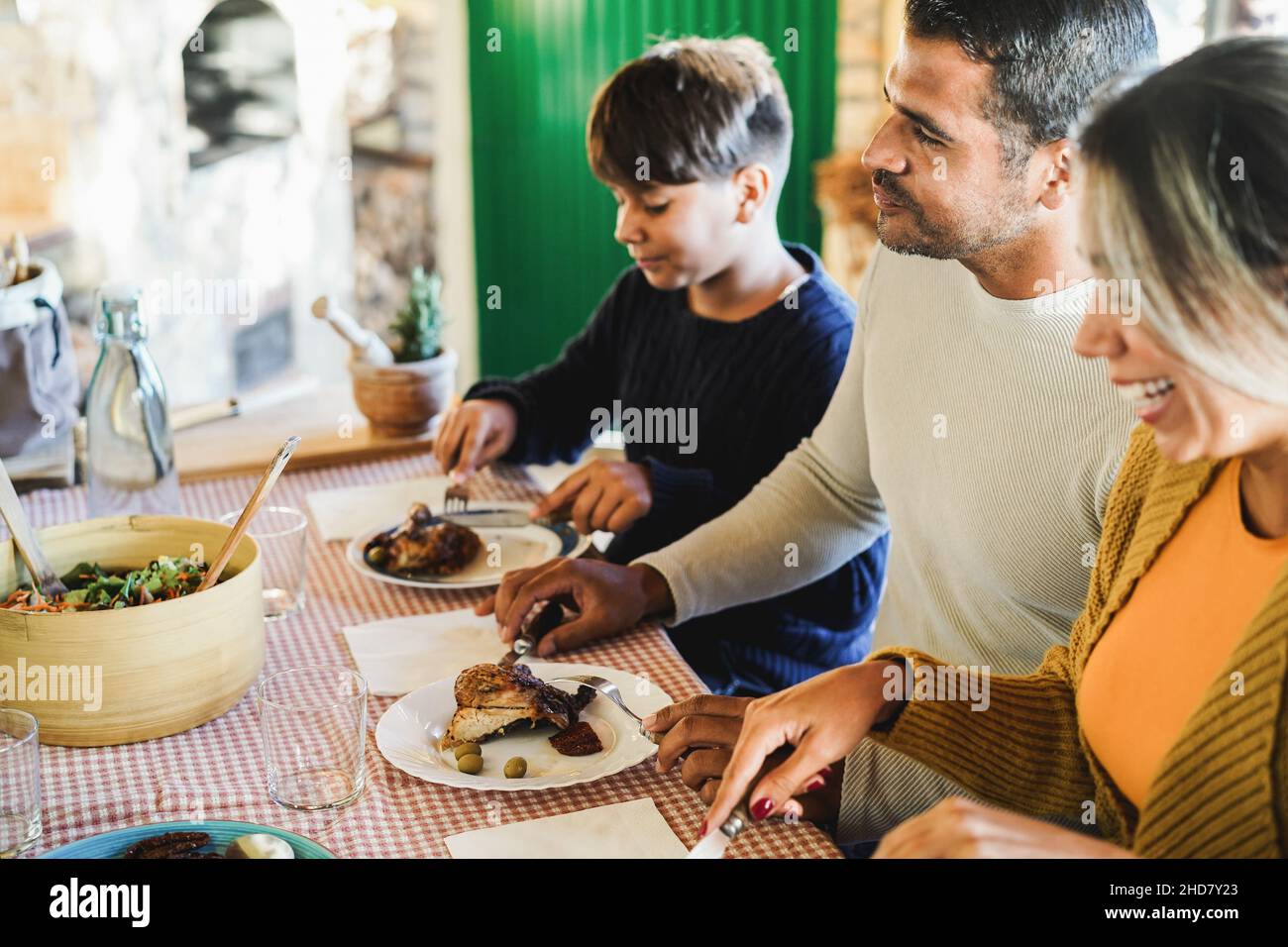 Latin parents having fun with their son during home dinner - Focus on father face Stock Photo