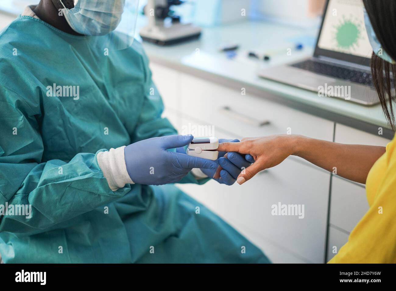 Doctor examining patient with fingertip pulse oximeter during coronavirus outbreak - Focus on woman hand Stock Photo