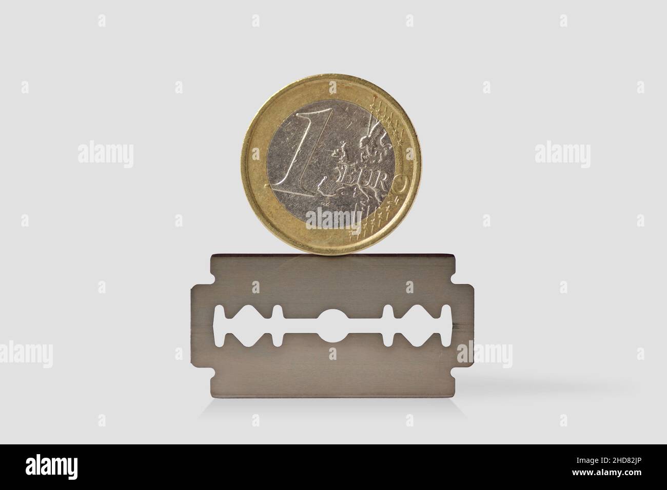 Coin Razor Inside Euro coin on razor blade - Concept of economy and financial risk Stock ...
