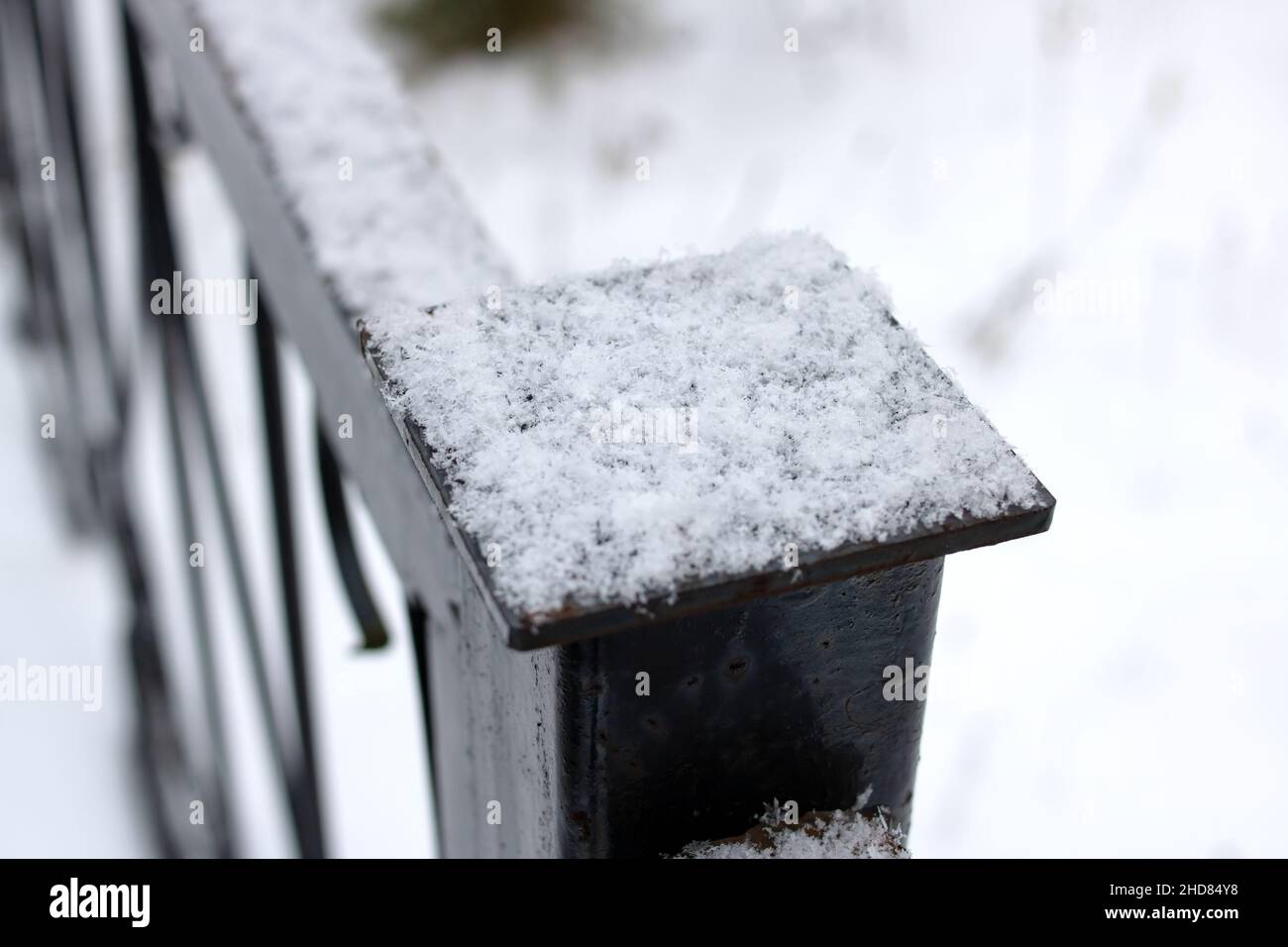 Snow on the black wrought iron railing close up Stock Photo - Alamy