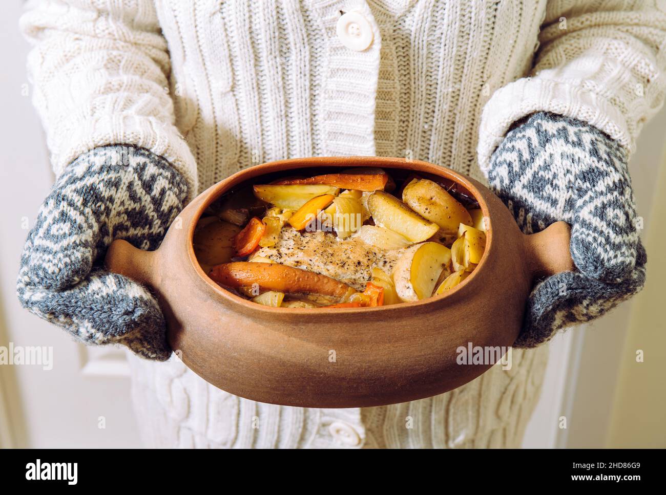 https://c8.alamy.com/comp/2HD86G9/woman-holding-terracotta-clay-cooking-pot-with-slow-cooked-pork-roast-and-vegetables-inside-wearing-knitted-clothing-winter-comfort-food-concept-2HD86G9.jpg