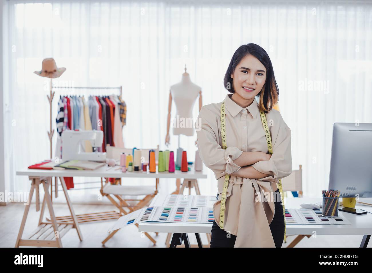 Portrait Asian designer clothes woman with cross one's arms in the office with success business. Startup designer concept. Clothes designers are worki Stock Photo