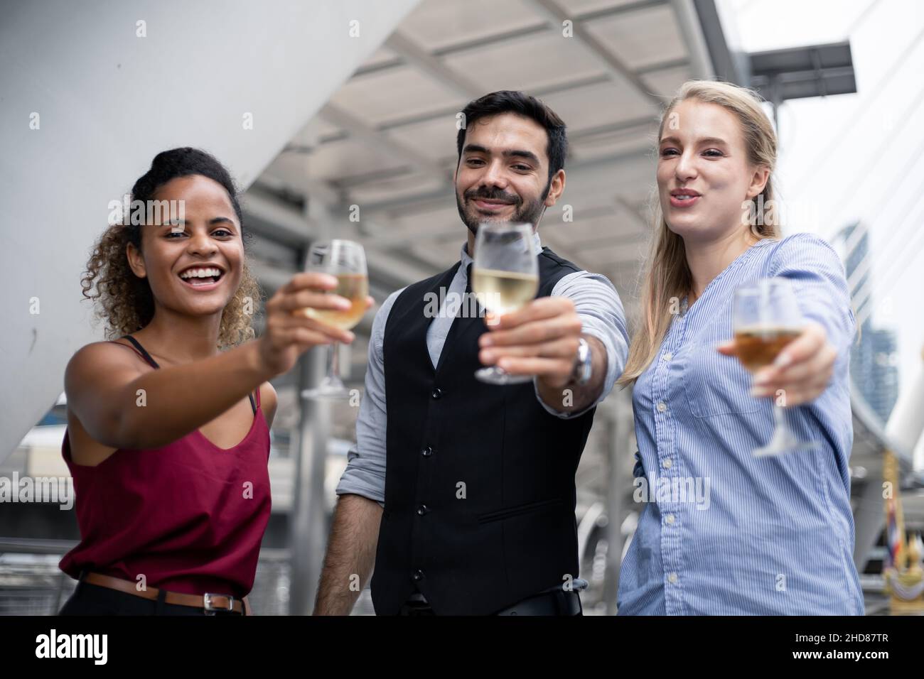 Business people clink glasses and drink wine to celebrate the successful work. Group of business people celebrate by drinking wine with smile. Stock Photo