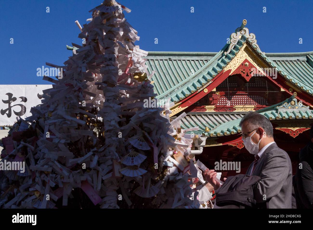 Tokyo, Japan. 04th Jan, 2022. A man leaves a fortune paper, called omikuji, as people visit Kanda Myojin Shrine on the first business day of the year to offer prayers and receive blessings.The shrine is dedicated to several gods of good fortune and thousands of company employees from across Tokyo as well as local people visit to pray for good luck and prosperity. (Photo by Damon Coulter/SOPA Images/Sipa USA) Credit: Sipa USA/Alamy Live News Stock Photo