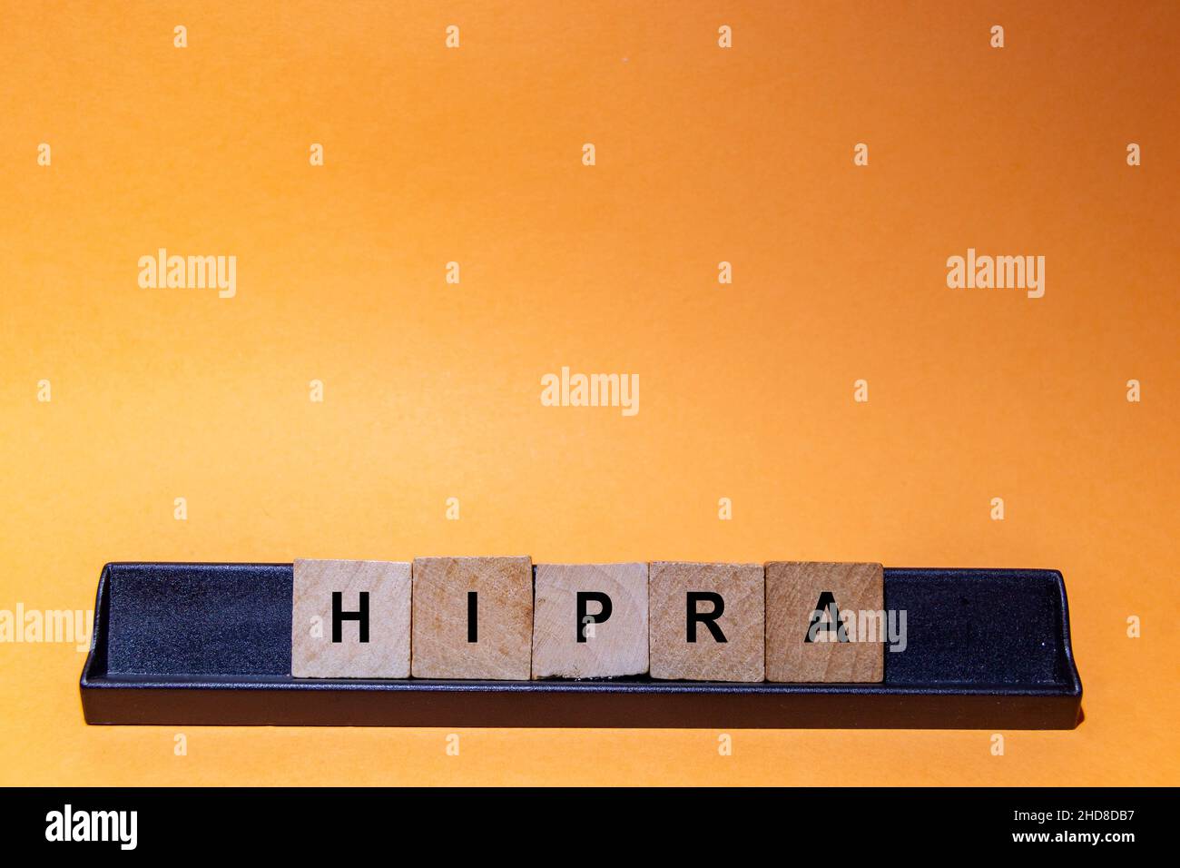 Hipra-Hypra, Spanish vaccine for the Coronavirus virus (Covid-19). Letters written on wooden index cards. Orange background with space for text. Stock Photo