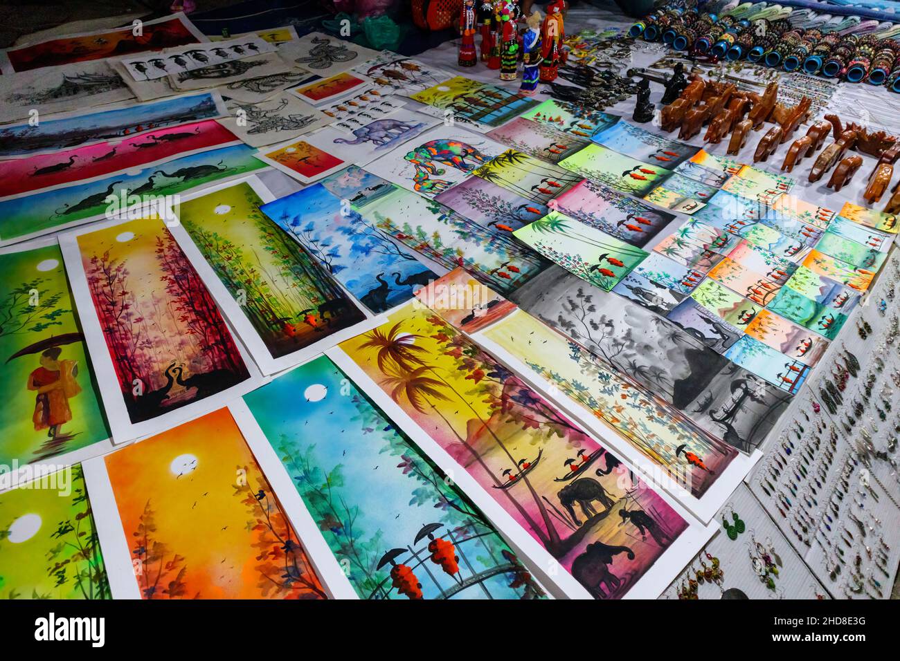 Typical local style paintings and pictures displayed in a stall in the walking street night market in central Luang Prabang, northern Laos, SE Asia Stock Photo
