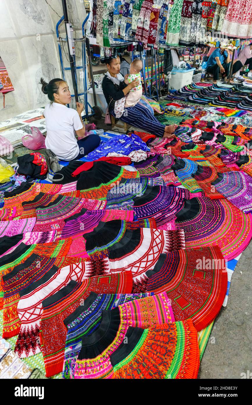 Colourful local style skirts and fabrics displayed in the walking street night market in central Luang Prabang, northern Laos, south-east Asia Stock Photo