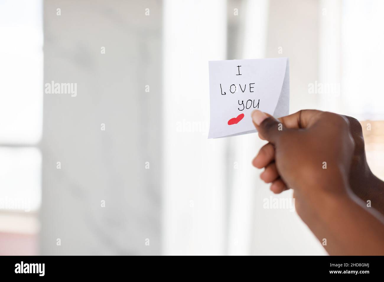 Black Female Hand Putting Sticky Note With Romantic Message On Mirror Stock Photo