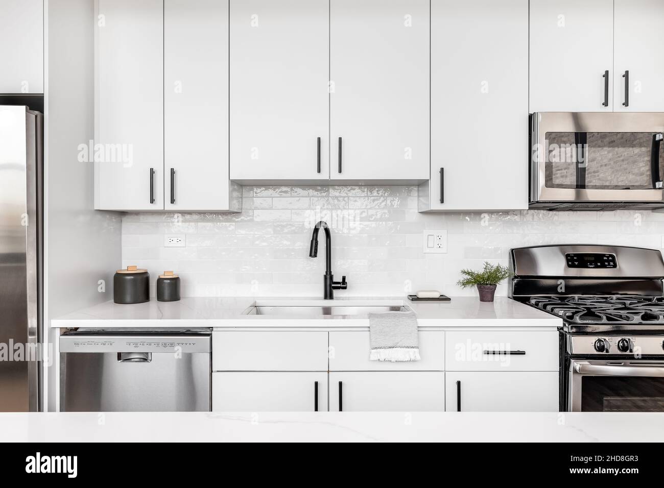 A beautiful white kitchen detail shot with a tiled backsplash, white ...